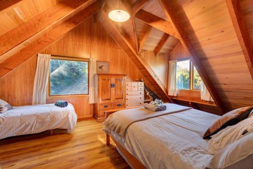 a bedroom with two beds in a wooden cabin at Charlies Cabin - Mt Lyford in Mt Lyford