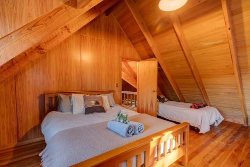 a bedroom with two beds in a wooden cabin at Charlies Cabin - Mt Lyford in Mt Lyford