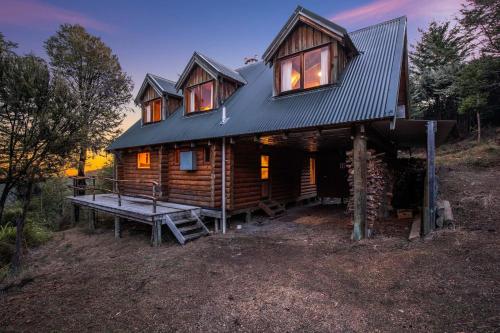 a log cabin with a bench in front of it at Charlies Cabin - Mt Lyford in Mt Lyford