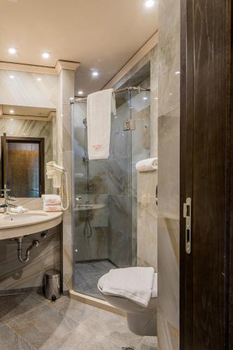 a bathroom with a shower and a toilet and a sink at Budapest Hotel - Free Parking in Sofia