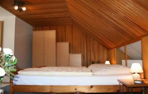 a bedroom with a large bed with a wooden ceiling at Pension Wiesner in Hameln