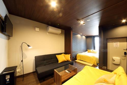 a living room with a couch and a bed at s-rea TOKYO 101 in Tokyo