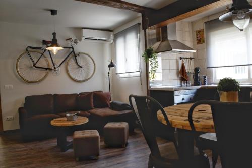 sala de estar con sofá y bicicleta colgada en la pared en Apartamento Cristo de la Luz, en Toledo