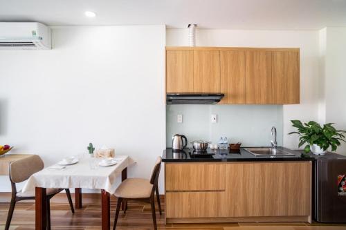 eine Küche mit einem Tisch und eine kleine Küche mit einem Waschbecken in der Unterkunft THE NAVIS Hotel & Apartment in Đà Nẵng