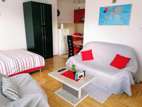 salon z białą kanapą i czerwonymi poduszkami w obiekcie Good Host w mieście Banja Luka