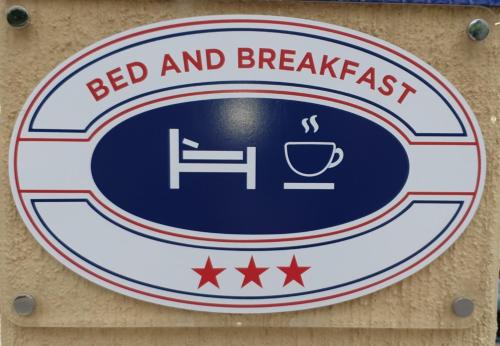 a sign for a bed and breakfast on a wall at La rosa dei venti in Villasimius