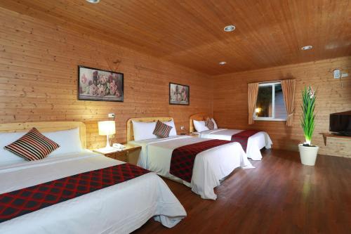 two beds in a room with wooden walls at Ying Shih Guest House in Datong