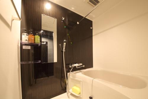 ein Badezimmer mit einer Dusche, einer Badewanne und einem Waschbecken in der Unterkunft s-rea TOKYO 101 in Tokio