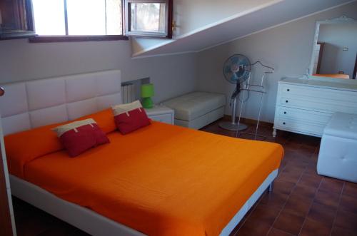- une chambre avec un lit et une couverture orange dans l'établissement Scerne Holiday Service Attic, à Scerne