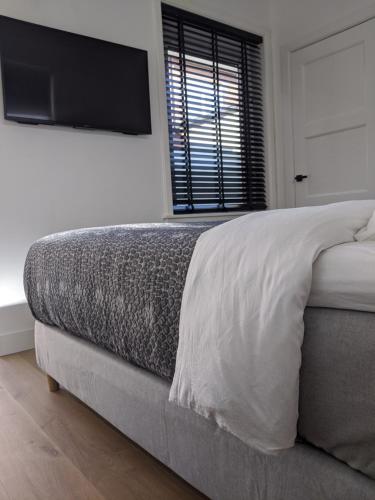 a bedroom with a bed with a television on the wall at Beachtime Suite in Zandvoort