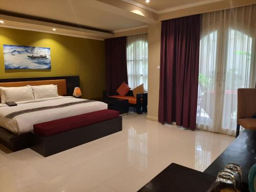 ein Schlafzimmer mit einem Bett und einem Sofa in einem Zimmer in der Unterkunft Novo Turismo Resort & Spa in Dili