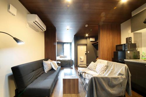 Una sala de estar con un sofá y un microondas. en s-rea TOKYO 201, en Tokio