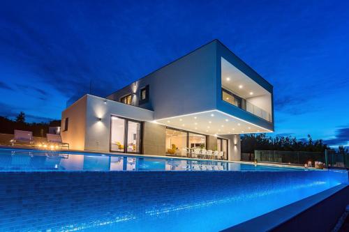 a house with a swimming pool at night at Villa SUNRISE DREAM in Grubine