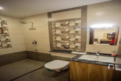 La salle de bains est pourvue de toilettes, d'un lavabo et d'un miroir. dans l'établissement Shri Ram Residency, à Jodhpur
