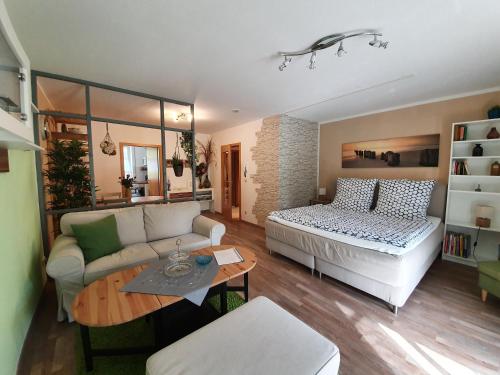 ein Wohnzimmer mit einem Bett und einem Sofa in der Unterkunft Ferienwohnung Ecksteinmühle in Prächting