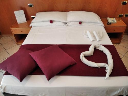 Una cama con almohadas rojas y blancas. en Hotel Zara Napoli, en Nápoles