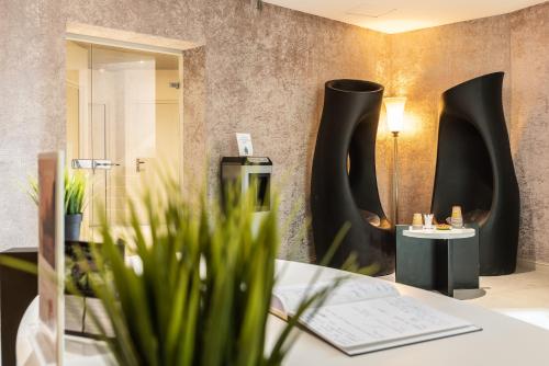a room with a table with plants and black vases at Domaine De Villers & Spa in Villers-sur-Mer