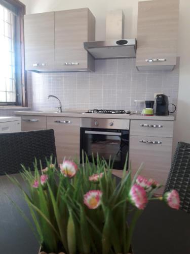 una cocina con una mesa con flores. en Sweet Home & Apartments, en Fontane Bianche