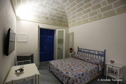 1 dormitorio con 1 cama y puerta azul en Il Ritrovo di Archimede, en Favignana