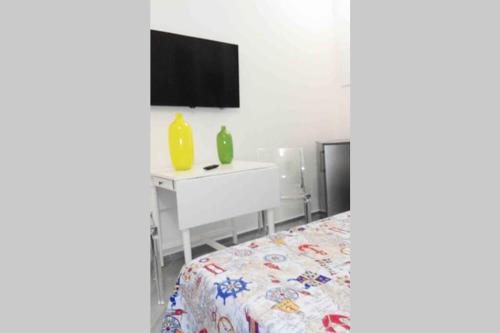 a bedroom with a bed and a sink and a tv at Il Ritrovo di Archimede in Favignana