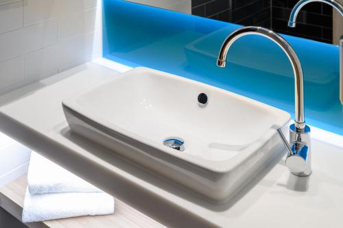 a white sink in a bathroom with blue at Holiday Inn Express Göttingen by IHG in Göttingen