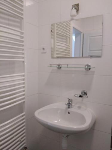 a white bathroom with a sink and a mirror at Diana Panzió in Mátrafüred