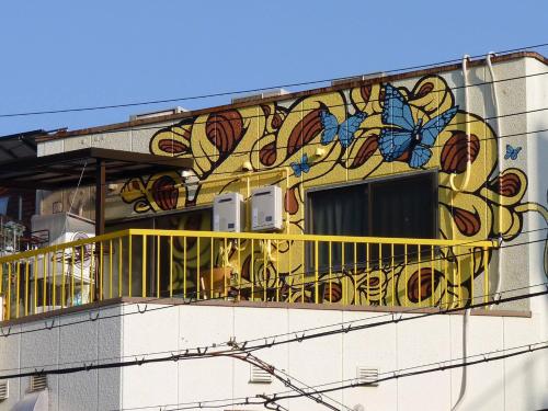 a building with a balcony with butterflies painted on it at DEER Hostel OSAKA NAMBA in Osaka