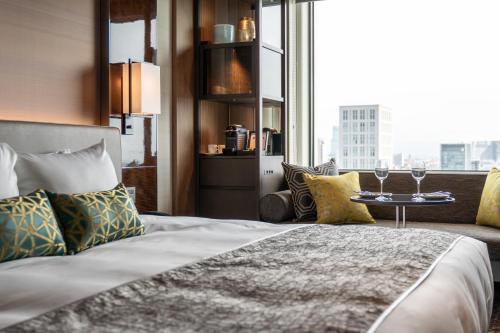 une chambre d'hôtel avec un lit et une table avec des verres à vin dans l'établissement The Royal Park Hotel Iconic Osaka Midosuji, à Osaka