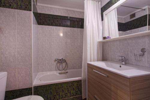 ein Badezimmer mit einer Badewanne, einem Waschbecken und einem WC in der Unterkunft Hotel Nefeli in Volos
