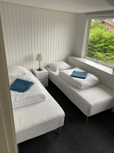 two beds in a room with a window at Second home in Herlev