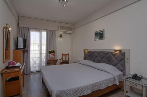 a bedroom with a large bed and a window at Hotel Nefeli in Volos