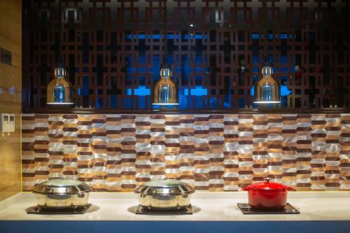 dos ollas y sartenes encima de una estufa en Shama Heda Serviced Apartment, en Hangzhou