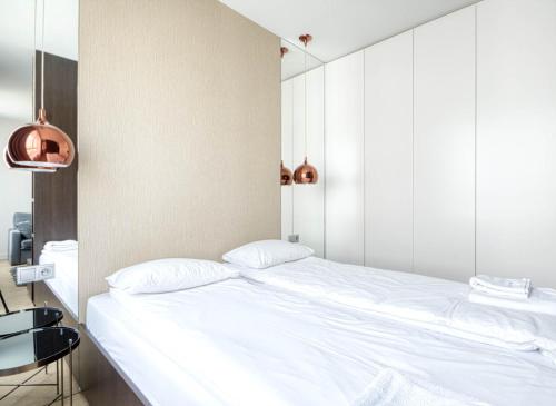 een slaapkamer met een wit bed en een tafel bij Wynalazek 2 by Homeprime in Warschau