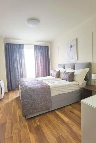 a bedroom with a large bed and a window at Aqua Viva Spa Hotel in Velingrad
