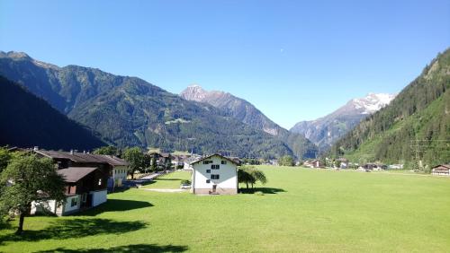 a village in a field with mountains in the background at Landhaus Eberler in Mayrhofen