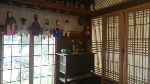 a room with windows and some dolls on the wall at Ahndong Kimjongtaek Yangsodang in Andong