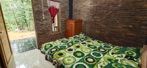 a bed in a room with a brick wall at Homestay Kurnia in Bantul