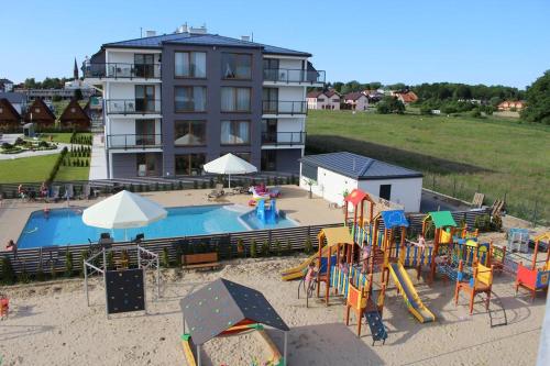 a playground with a pool and slides and a building at Apartamenty Rodzinne Deluxe, Suite w budynku Baltin in Sarbinowo