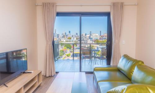 a living room with a couch and a large window at The Windsor, Hotel Rooms & Apartments in Brisbane