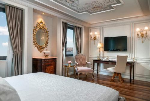 a hotel room with a bed and a desk and a television at Rixos Pera Istanbul in Istanbul