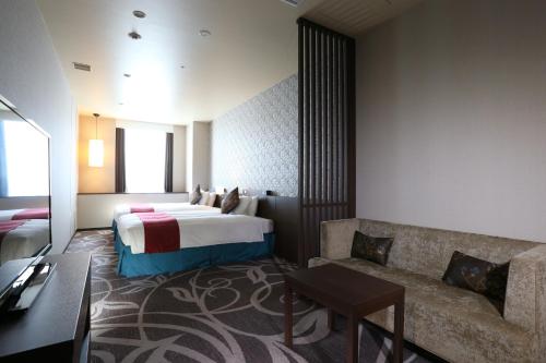 a hotel room with a bed and a couch at Quintessa Hotel Osaka Bay in Osaka