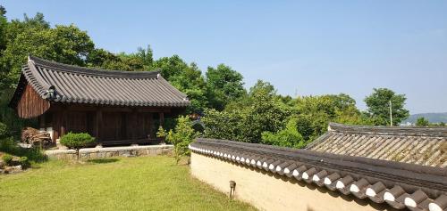 a building with a brown roof and some trees at Ahndong Kimjongtaek Yangsodang in Andong