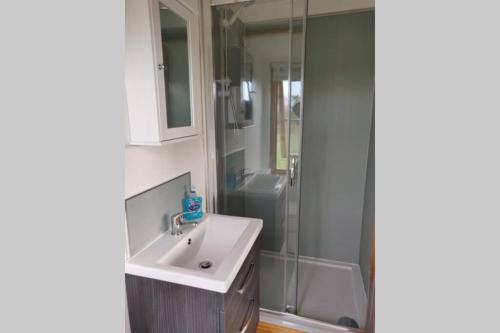 een badkamer met een wastafel en een douche bij The Cabin in Millom