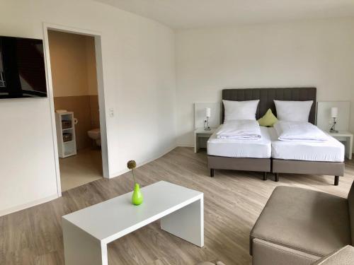 a bedroom with a bed and a table and a couch at ADAPT Apartments Braunschweig in Braunschweig