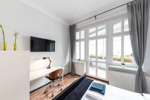 a hotel room with a desk and a window at Villa Wilda in Poznań