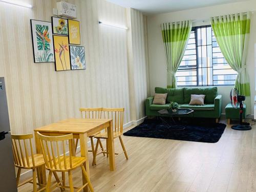 a living room with a table and a green couch at LY'S Căn hộ Homestay Phan Rang-2pn in Phan Rang–Tháp Chàm