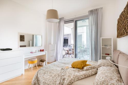 a white bedroom with a bed and a desk at Porto Fluviale House in Rome