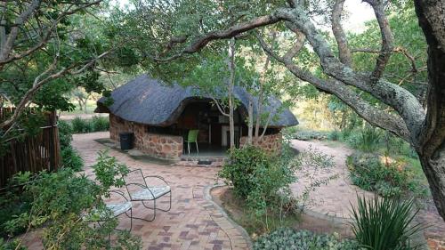ein Haus mit einem Dach mit einer Schaukel im Garten in der Unterkunft Shondoro Mountain Retreat in Vaalwater