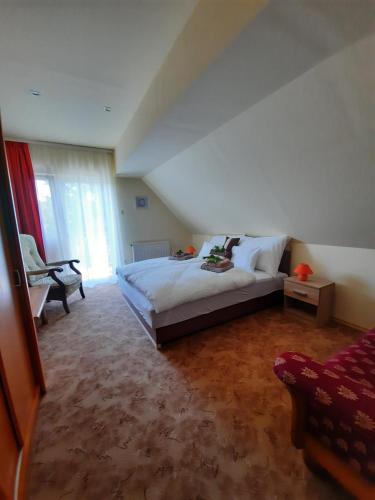 a bedroom with a large bed and a window at Harmónia Vendégház in Balatonalmádi