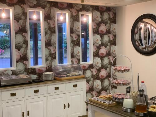a kitchen with a counter with flowers on the wall at Hotel Restaurant Baryton in Saint-Marcel